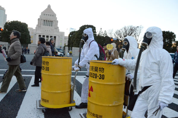 タイベックを着た参加者が「放射性廃棄物」と書かれたドラム缶を押して歩く。反原発集会ならではのパフォーマンスだ。=写真：田中龍作=