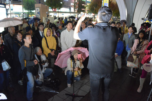 雨のなか聴衆は身じろぎもせずに山本議員の話に耳を傾けた。= 9日夕、名古屋駅前　写真：筆者 =