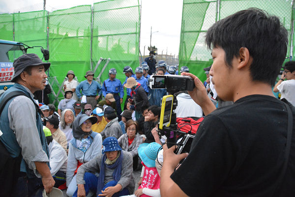 仁尾氏のカメラワークは徹底した住民目線だ。沖縄平和運動センターの山城博治議長（左）も氏に厚い信頼を寄せる。=14日朝7時頃、名護市　写真：筆者=