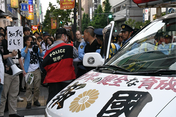 右翼は歩道上の市民に つかみかかろう としたが、警察に制止された。＝3日午後６時01分、西新宿　撮影：田中龍作＝