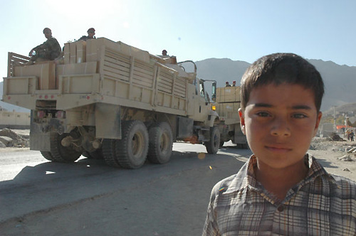 ゴルバッグ村の少年。後ろを行くのは国軍のトラック。