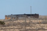 カダフィ軍が火を放った石油貯蔵タンク。反政府軍兵士によれば施設の周囲には地雷が敷設されている。筆者はアスファルト道路から外に出ないようにしてカメラのシャッターを切った。（石油積み出し港ブレガー。写真：筆者撮影）