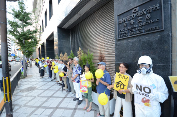 黄色い風船を持った市民たちで包囲された関電京都支店。（写真：田中撮影）