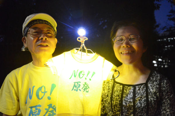 横浜市から訪れた老夫婦が製作したTシャツは、孫と同じサイズ。スイッチオンにするとLED電球に灯りがともり『NO 原発』の文字が浮かびあがった。=3日夕、国会議事堂前。写真：諏訪撮影=