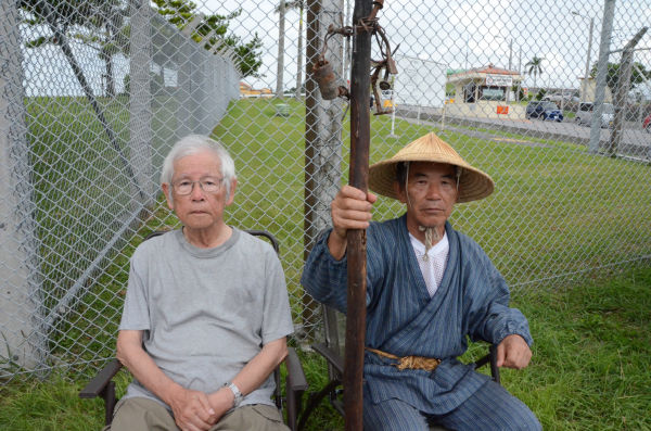上原成信さん（85歳・左）と小橋川共行さん（69歳・右）。2人は今月、オスプレイ配備反対集会で知り合ったばかりだ。=16日夕、キャンプ・フォスター前。写真：田中撮影=