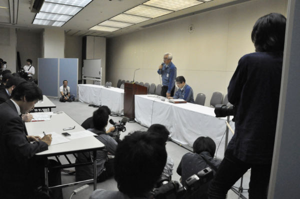 原発事故後間もない頃の東電記者会見。答弁しているのは武藤栄副社長。右隣りに座っているのは松本純一・原子力立地本部長代理（いずれも当時）。＝東電本店　写真：田中龍作＝