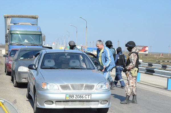 ウクライナ本土から入って来る車両を止めて検問する民兵。チェックポイントではこの角度のみ撮影を許可された。＝12日午後1時ごろ（日本時間午後7時ごろ）チョンガル検問所　写真：筆者＝
