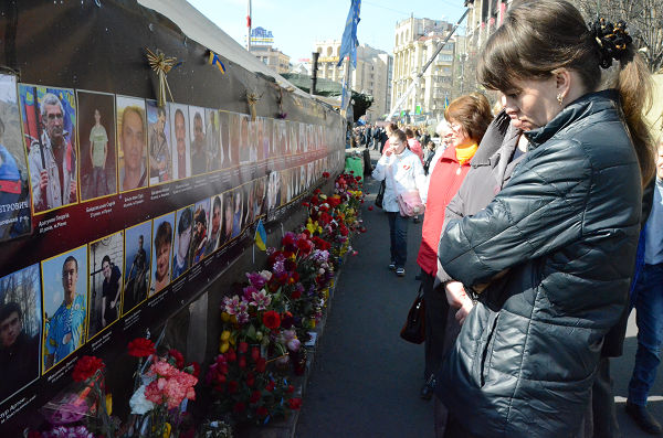 犠牲者88人の遺影を見つめる人々。ある男性（30代）は「マイダン（独立広場）の戦いはすべて政治家のためだった」と話した。＝キエフ市内　写真：筆者＝