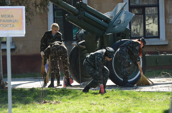 投降が決まり基地の庭を掃くウクライナ軍の女性兵士たち。＝22日、シンフェロポル　写真：筆者＝