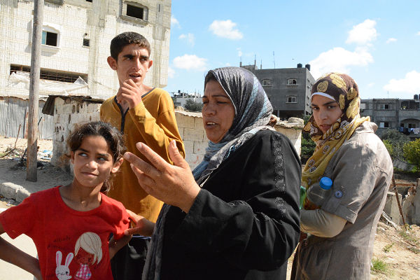 退避する家族。母親はイスラエルの爆撃に憤っていた。=18日、ベイト・ラフィーヤ