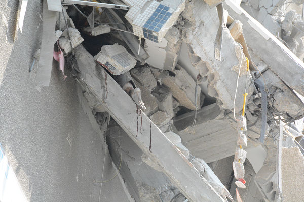 瓦礫に挟まれた男性の足が見える～写真・中央～。救出しようにもままならない。＝22日午前10時頃（日本時間同日午後4時頃）、ガザ市内　写真：筆者＝