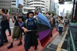 新宿で反戦を訴え続ける大木晴子さんは七色のパラソルを振りながら沿道の人々にアピールした。（5日、靖国通り　写真：　田中　）