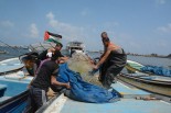 収ってあった漁網を船に積み込み出漁する漁師たち。＝5日、ガザ市海岸　写真：筆者＝