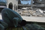 イスラエル軍に破壊されたモスクの傍らで祈りを捧げるイスラム教徒。＝15日、ガザ市内　写真：筆者＝