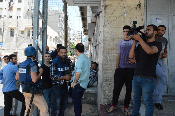 イスラエル軍から警告弾を落とされ、取材拠点のビルから脱出したパレスチナ人記者たち。6時間後に「本爆撃」があった。＝7月27日、ガザ市内　写真：筆者＝