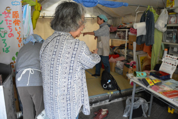 襲撃犯によってグチャグチャにされたテントの中を修復する女性たち。＝13日、経産省前　写真：筆者＝　