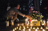 抗議の男性が身を焼いた場所に花束を供える。＝10日夜、日比谷公園　写真：筆者＝