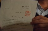 岸田外務大臣名で発出された「一般旅券返納命令書」。命令書を手にしているのは杉本氏。＝12日、日本外国特派員協会　写真：筆者＝