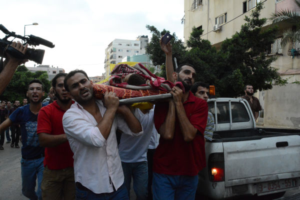 イスラエル軍の空爆で殺された子供の遺体をモスクに運ぶ。＝2014年7月、ガザ市内　写真：筆者＝　