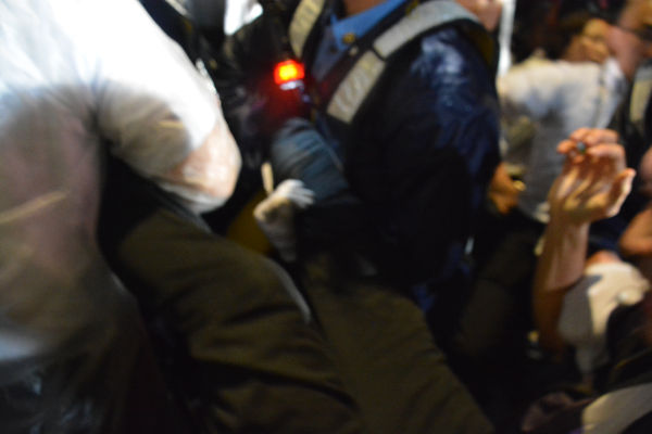 足から持って行かれる逮捕者。警察はなりふり構わなかった。＝16日夜、国会正門前　写真：筆者＝