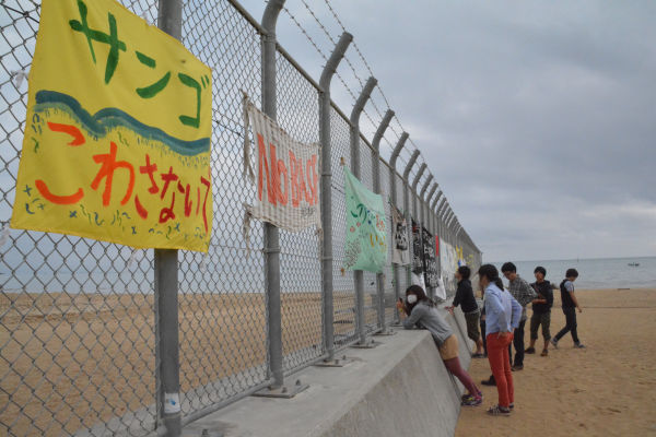 日本政府は米軍基地のためサンゴの海を埋め立てるつもりだ。=辺野古、フェンスの向こうはキャンプシュワブ　写真：筆者=