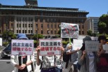 「レッドパージ」「民主主義を破壊するな」のプラカードを掲げる市民。「なめんなよの精神を」は憲法記念日に発行された神奈川新聞の別刷り。＝12日、神奈川県議会前　撮影：筆者＝