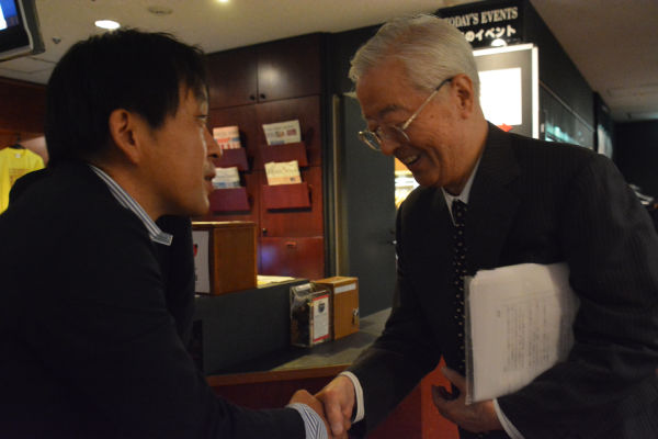 握手を交わす田久保会長と菅野完氏。いちばん話がしたかったのは会長ではなく事務総長の方だったろうに。=13日、東京・外国特派員協会。撮影：田中=