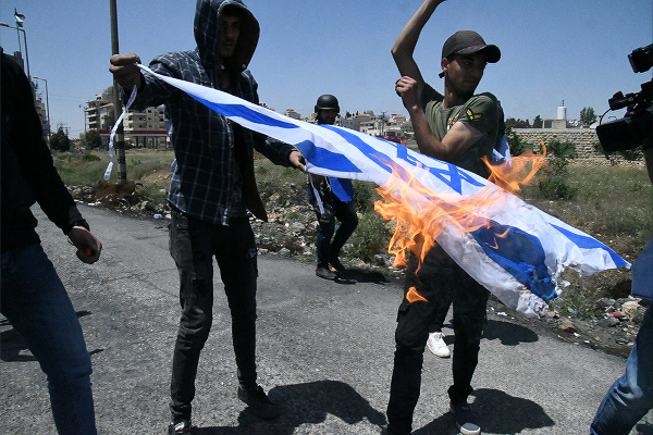 少年たちはガソリンをかけてイスラエル国旗を燃やした。当然、イスラエル軍の目に入る。＝11日、ヨルダン川西岸　撮影：田中龍作＝