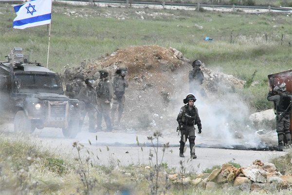 パレスチナ自治区に侵攻してきたイスラエル軍部隊。白く煙っているのは催涙ガス。＝4日、ラマッラ　撮影：田中龍作＝