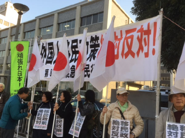 「移民政策、絶対反対」。抗議のプラカードと日章旗が官邸前に翻った。＝27日午後、永田町　撮影：筆者＝