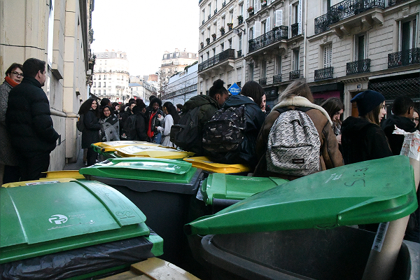 校門前にはゴミ収集箱が隙間なく並べられた。マクロン大統領の教育改革に反対する生徒たちで溢れる。＝18日朝8時頃、パリ市内　撮影：田中龍作＝
