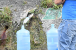 山から染み出てくる水をボトルに詰める市民。ゴミ漁りと同じく当たり前の光景となっている。＝カラカス郊外　撮影：田中龍作＝