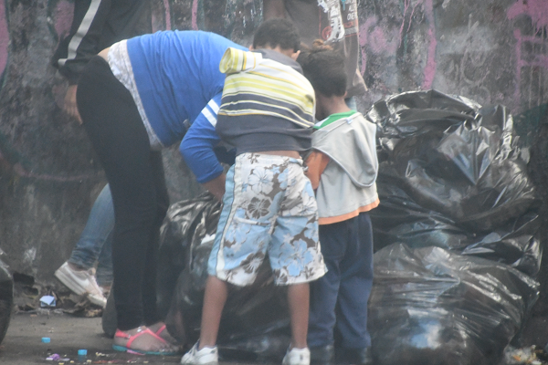 子供たちと共にゴミを漁る母親は妊娠中だった。マドゥロ大統領は「人道危機はない」と主張する。ゴミ袋漁りはタブーだ。撮影した米TVのジャーナリストは国外追放となった。＝2月、カラカス市内　撮影：田中龍作＝