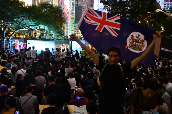 カメラが向くと男性は英連邦旗を掲げてみせた。＝16日、香港　撮影：田中龍作＝