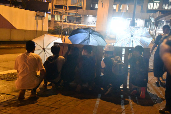 香港版天安門事件を引き起こした旺角警察署が正面に迫る。小さな背中がバリケードを支える。右から４人目が14歳の女の子。＝3日、太子　撮影：田中龍作＝