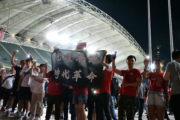 ハーフタイム。若者たちは観客席で革命スローガンの横断幕を広げた。＝10日夜、香港スタジアム　撮影：田中龍作＝