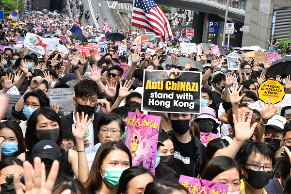人々は「5大訴求」を示す5本指を掲げながら米国総領事館に向けてデモ行進した。「ChiNAZI」とは「中国とナチス」という意味の造語だ。＝8日、中環　撮影：田中龍作＝