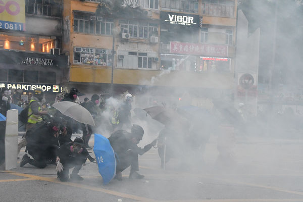 警察は雨あられのごとく催涙弾を撃ち込んだ。デモ隊は怯まず、ジワジワと前進を続けた。＝20日、旺角　撮影：田中龍作＝