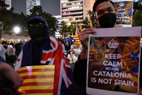 CATALONIA IS NOT SPAIN. 香港の反政府デモ・スローガンのひとつ「Hong Ｋong is not China」と同じだ。プラカードを持つ男性は「カタルーニャの事が他人事とは思えない」。＝24日夜、遮打花園　撮影：田中龍作＝