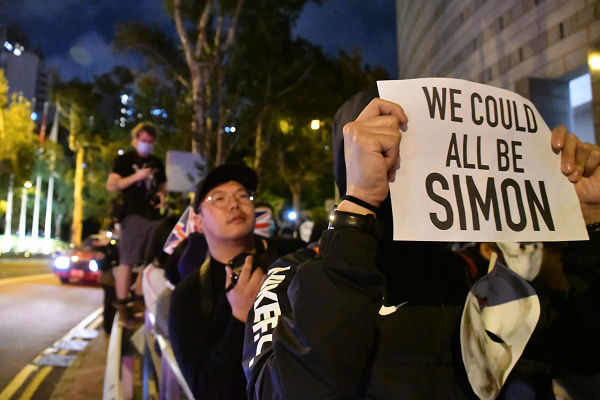 「私たちの誰もがサイモンになる可能性がある」。プラカードが香港市民の危機感を表していた。＝29日夜、英国総領事館前　撮影：田中龍作＝