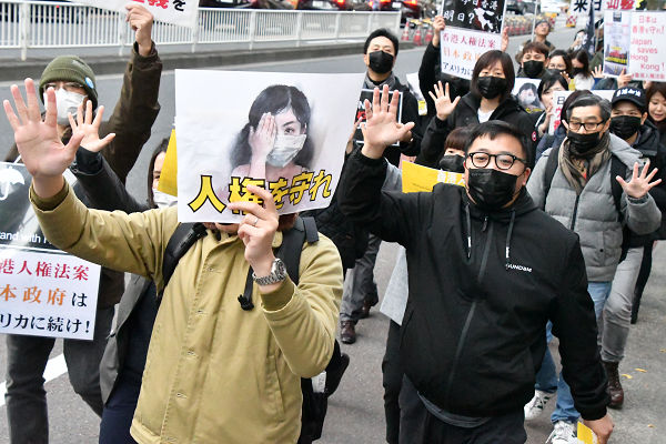 香港人たちは現地と同じように「Five Demands」を示す５を掲げながらデモ行進した。＝15日、新橋付近　撮影：田中龍作＝
